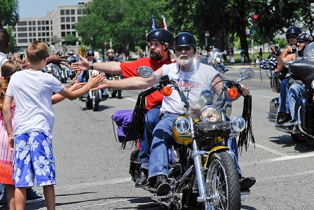 Kids give motocycle riders a high five